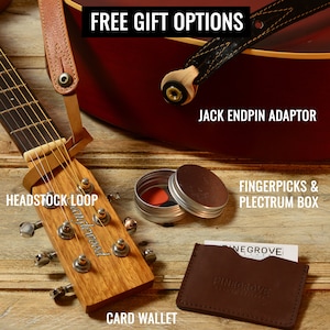 May include: A close-up of a wooden guitar headstock with a brown leather strap, a small tin with fingerpicks, a brown leather card wallet, and a brown leather guitar strap with a black endpin adaptor. The text "FREE GIFT OPTIONS", "HEADSTOCK LOOP", "anglewood", "JACK ENDPIN ADAPTOR", "FINGERPICKS & PLECTRUM BOX", "CARD WALLET", "NEGROVE", and "PINAGROVE" is visible in the image.