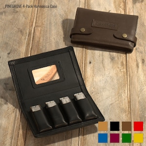 May include: A black leather harmonica case with a brown leather flap. The case has a window on the front that shows a harmonica inside. The case is labelled "PINEGROVE 4-Pack Harmonica Case".