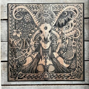 May include: Black and white woodblock print of a woman with a skull headdress and a Celtic knot border.