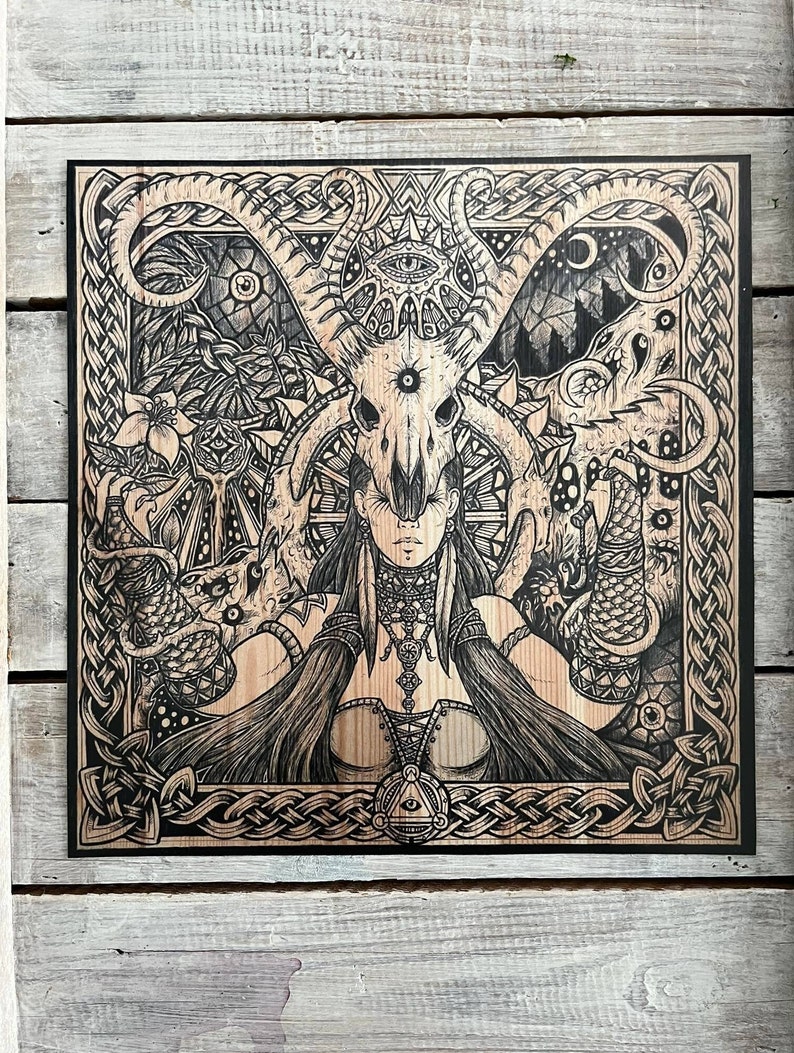 May include: Black and white woodblock print of a woman with a skull headdress and a Celtic knot border.