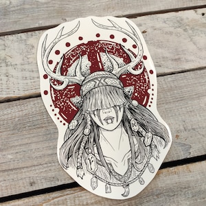 Peut inclure: Un dessin au trait noir et blanc d'une femme aux cheveux longs portant une coiffe avec des bois de cerf. La coiffe est entourée d'un cercle rouge avec des points blancs. La femme a un visage stylisé avec un motif rouge et blanc.