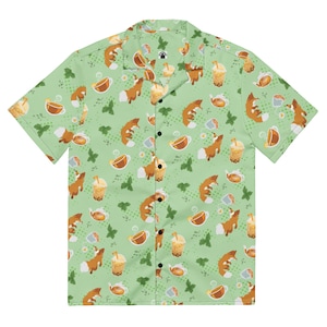 May include: A short-sleeved button-down shirt with a light green background. The shirt features a repeating pattern of cartoon foxes, tea cups, boba tea, and tea pots. The foxes are brown and white, and the tea cups and boba tea are shades of brown and yellow.