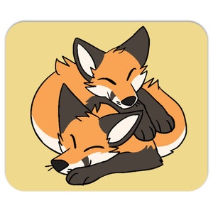 以下が含まれることがあります： 2匹のキツネの漫画イラストが描かれた正方形のマウスパッド。キツネはオレンジと白で、黒のアクセントがあり、一緒に丸まって眠っています。背景は薄い黄色です。