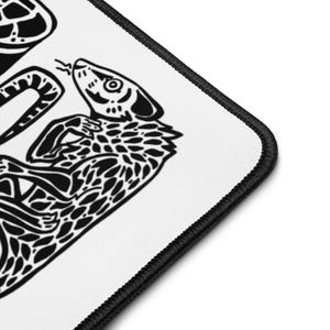 Puede incluir: Alfombrilla de ratón blanca con borde negro. Presenta una ilustración en blanco y negro de una serpiente y una tortuga. La serpiente está enroscada y la tortuga está en la esquina superior izquierda.