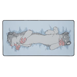 May include: A rectangular mousepad featuring a cartoon illustration of two stylized, light gray and white animals with pink paw pads, lying on a light blue surface. The animals are in a relaxed pose, with their eyes closed.