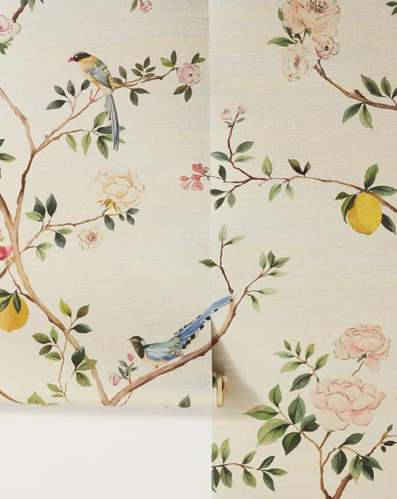 K&ouml;nnte beinhalten: Eine cremefarbene Tapete mit einem floralen und Vogeldesign. Die Tapete zeigt rosa und wei&szlig;e Blumen, gr&uuml;ne Bl&auml;tter und blaue V&ouml;gel.