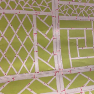 May include: A green and white wallpaper with a geometric pattern of overlapping squares and diamonds. The pattern is reminiscent of a bamboo trellis.