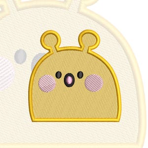 May include: A yellow embroidered patch featuring a stylised character with two rounded ears, two small black eyes, a central black oval mouth with a pink centre, and two circular pink cheeks, all outlined in a thick yellow border.