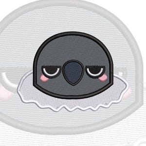 May include: An embroidered patch featuring a stylised dark grey bird head with closed eyes, a dark blue beak, and small pink cheeks. The bird is positioned above a white, scalloped, cloud-like shape, all outlined in black thread on a white background.