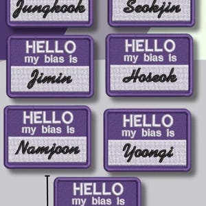 May include: Purple embroidered patches with the text "HELLO my bias is" and various names: Jungkook, Seokjin, Jimin, Hoseok, Namjoon, Yoongi, and Taehyung. Each patch is approximately 3 inches in height.