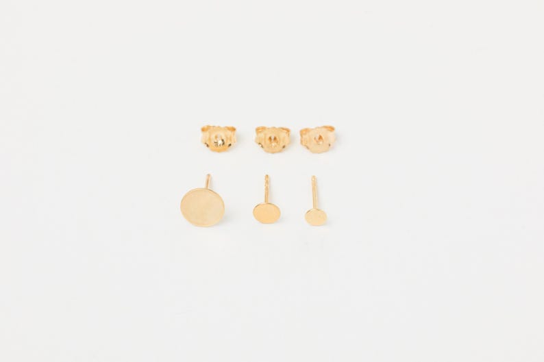 May include: Set of three gold-toned stud earrings. The earrings are round and have different sizes.