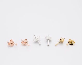 May include: Four pairs of earring posts in different metal finishes: gold, silver, rose gold, and silver. The posts are all the same size and shape.