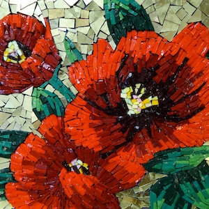 K&ouml;nnte beinhalten: Ein Mosaikkunstwerk mit drei leuchtend roten Blumen mit dunklen Zentren und gelben Akzenten. Die Blumen sind von gr&uuml;nen Bl&auml;ttern umgeben und vor einem Hintergrund aus goldfarbenen Fliesen angeordnet. Die Mosaikarbeit ist eine Nahaufnahme, die die detaillierte Handwerkskunst zeigt.
