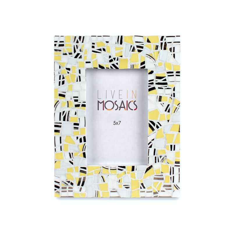 May include: A rectangular photo frame with a mosaic design. The frame is decorated with small, irregular pieces in yellow, white, and black. The text "LIVE IN MOSAICS" and "5x7" are visible within the frame's opening.