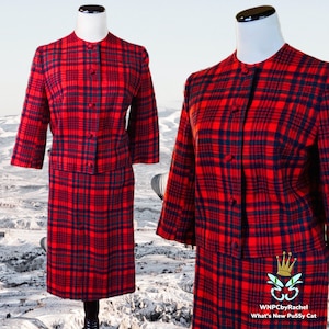 Puede incluir: Un traje de falda rojo y negro a cuadros con una chaqueta abotonada y una falda hasta la rodilla. El traje está en un maniquí blanco.