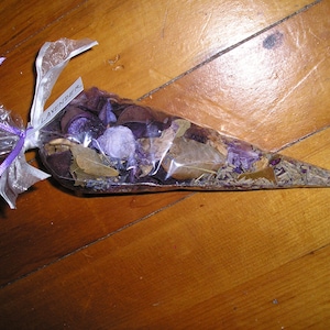 May include: A clear plastic cone filled with dried lavender, leaves, and flowers. The cone is tied with a purple ribbon and a label that reads "Lavender".