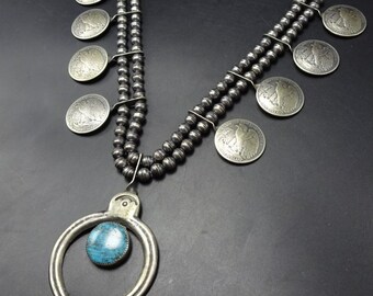 May include: A silver necklace with a turquoise pendant and silver coin charms. The necklace is made of two strands of silver beads.