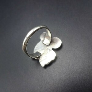 May include: A silver ring with a floral design. The ring is made of sterling silver and has a polished finish.