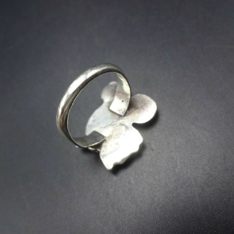 May include: A silver ring with a floral design. The ring is made of sterling silver and has a polished finish.