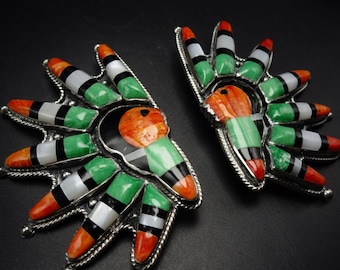 Könnte beinhalten: Ein Paar silberne Ohrringe mit einem indianischen Design. Die Ohrringe sind aus Türkis, Koralle und Perlmutt gefertigt. Die Ohrringe haben die Form eines Sonnenstrahls.
