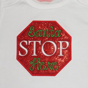 Op de afbeelding: Witte romper met een rood stopteken met de tekst "Santa Stop Here" in groene en witte letters.