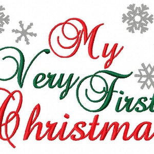 May include: Red and green cursive text reads "My Very First Christmas" with gray snowflake designs around the text.