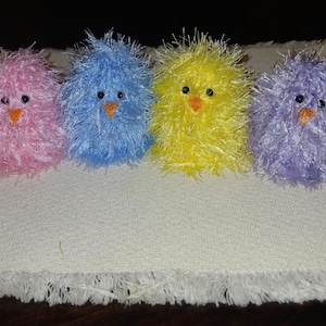 May include: A white ceramic mug with a black handle and the text "But First, Coffee" in a bold, black font. The mug is filled with a dark liquid, likely coffee, and sits on a light-colored surface.