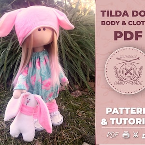 Peut inclure: Une poupée Tilda rose avec des oreilles de lapin roses et une robe à fleurs, tenant un lapin blanc avec des oreilles roses. L'image comprend le texte "Tilda Doll Body & Clothes PDF Pattern & Tutorial PDF"