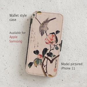 May include: A wallet-style phone case with a floral design featuring a bird and pink flowers. The case is available for Apple and Samsung phones. The model pictured is an iPhone 11.