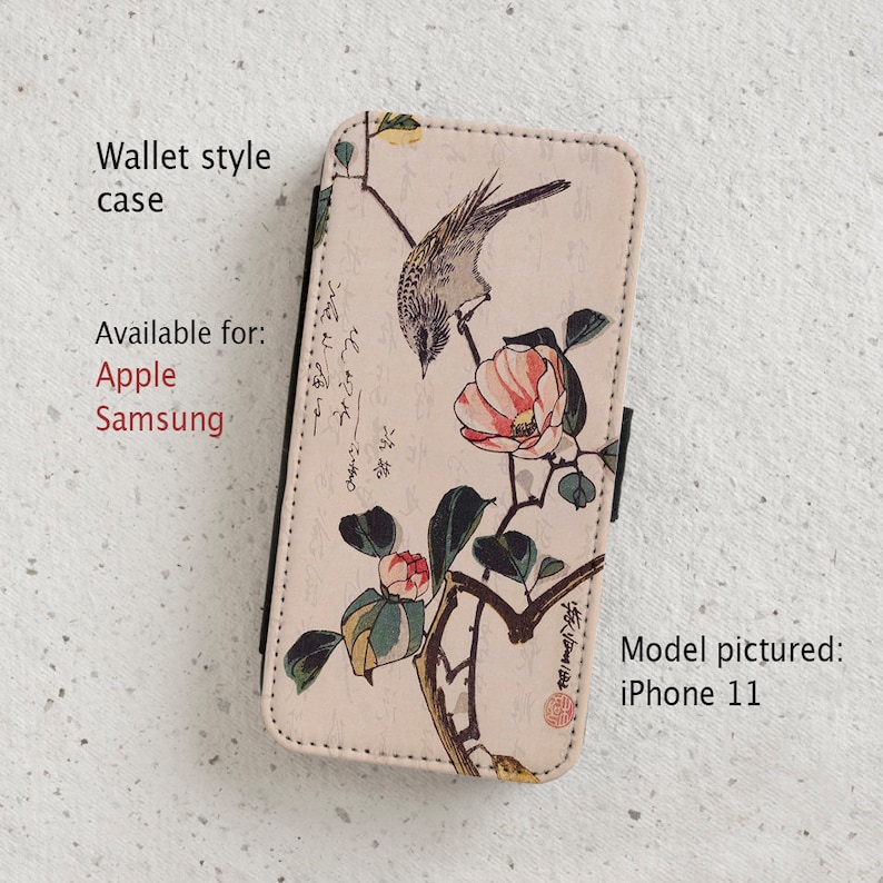 May include: A wallet-style phone case with a floral design featuring a bird and pink flowers. The case is available for Apple and Samsung phones. The model pictured is an iPhone 11.