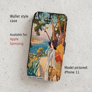 May include: A vintage travel poster for Antibes, Cote d'Azur, France, featuring a woman in a blue dress and a hat, holding an umbrella, walking with a dog. The poster is printed on a wallet style phone case.
