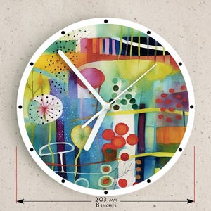 May include: A round wall clock with a white frame and a colorful abstract design. The clock face features a watercolor-style painting with shades of blue, yellow, red, and green. The clock is 8 inches in diameter.