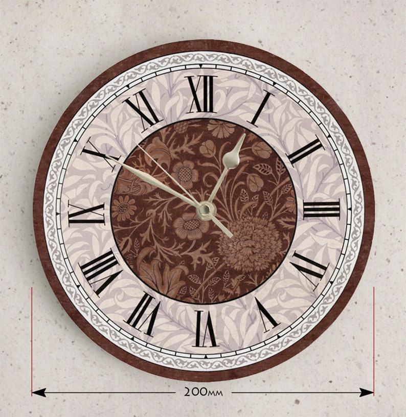 May include: A brown and white round wall clock with Roman numeral markings and a floral design. The clock is 8 inches in diameter.