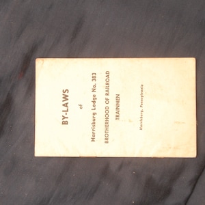 May include: A white booklet with the title "BY-LAWS of Harrisburg Lodge No. 383 BROTHERHOOD OF RAILROAD TRAINMEN Harrisburg, Pennsylvania"