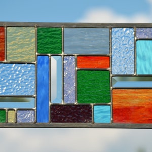 hanging stained glass panel in leaded construction with glass chosen representing  4 seasons