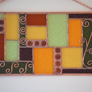 closeup showing copper accents, frame and solder in handmade stained glass panel