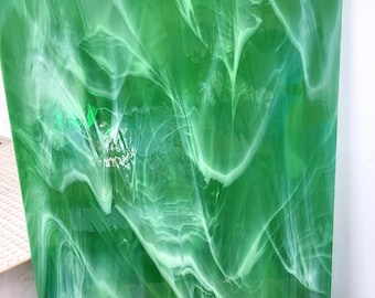 May include: A sheet of green glass with white swirls throughout. The glass has a translucent, almost cloudy appearance.
