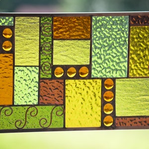 closeup of textures in handmade stained glass panel with wire accents and copper coloring of lead, copper frame