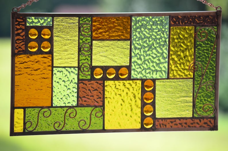 closeup of textures in handmade stained glass panel with wire accents and copper coloring of lead, copper frame