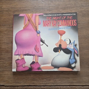 May include: A vintage Bloom County comic book cover titled "The Night of the Mary Kay Commandos" featuring cartoon characters. The cover art includes a woman in a pink dress with a machine gun and other cartoon characters.