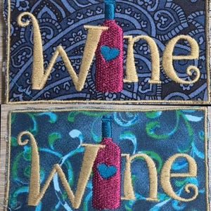May include: Embroidered patches with the word "Wine" in gold script, featuring a wine bottle with a blue heart. The background fabric has a blue paisley and a teal swirl design. The patches are rectangular.