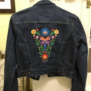 Denim jacket embroidered with Las Flores butterfly design