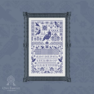 Puede incluir: Un patrón de punto de cruz enmarcado con un alfabeto azul y blanco, pájaros y diseños florales. El patrón se titula "Raven Alphabet".