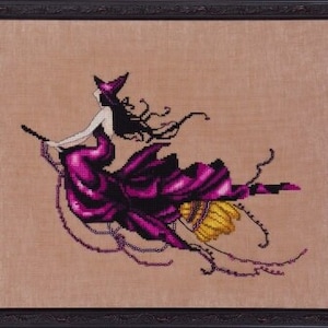 May include: A purple and black witch flies on a broomstick with a yellow and gold handle. The witch is wearing a purple dress and a black hat. The background is a light brown.