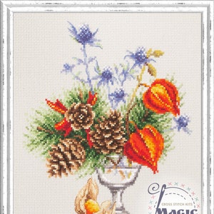 Könnte beinhalten: Ein Kreuzstichmuster mit einer Vase, gefüllt mit Tannenzapfen, roten und orangefarbenen Blumen und blauen Disteln. Die Vase steht auf einem weißen Hintergrund mit dem Text "CROSS STITCH KITS MAGIC NEEDLE" in der rechten unteren Ecke.