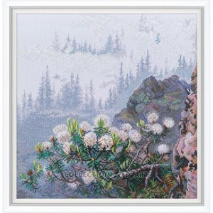 May include: A cross-stitch pattern featuring a misty mountain scene with white flowers in the foreground. The background shows a forest and mountains in the distance.