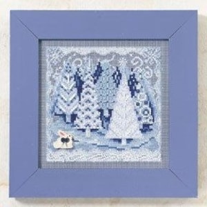 May include: A square cross-stitch embroidery featuring a winter forest scene with white and blue pine trees, set within a solid periwinkle blue wooden frame. A small white rabbit with a black bow is positioned in the lower left corner of the design.