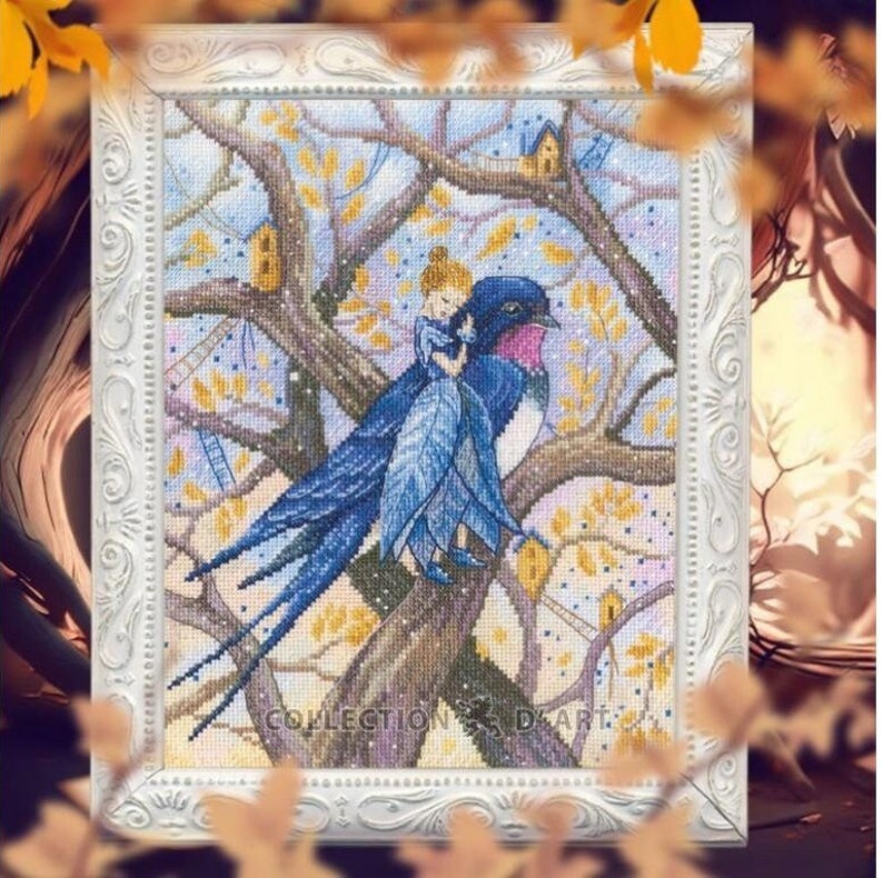 Op de afbeelding: Een kruissteekpatroon met een blauwe vogel waarop een kleine fee rijdt. De vogel zit op een tak van een boom met gele bladeren. De achtergrond is lichtblauw met witte sneeuwvlokken. De tekst "COLLECTION'S D'ART" staat onderaan de afbeelding.