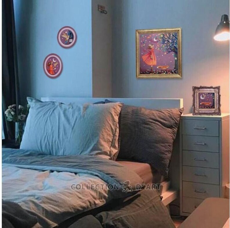 Puede incluir: Un interior de dormitorio con una cama, una c&oacute;moda y tres cuadros enmarcados en la pared. Los cuadros muestran a una ni&ntilde;a con un vestido rojo, un p&aacute;jaro y una luna. La cama tiene un edred&oacute;n azul y blanco y dos almohadas. La c&oacute;moda es blanca con seis cajones. Las paredes son de color azul claro.