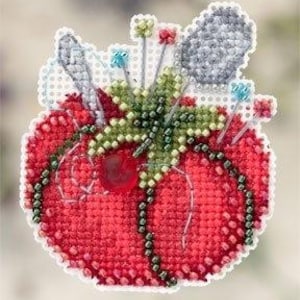May include: A cross-stitched tomato pin cushion with a variety of pins and needles. The tomato is red with green leaves and a beaded black chain. A gray pincushion and a red bead are also visible.